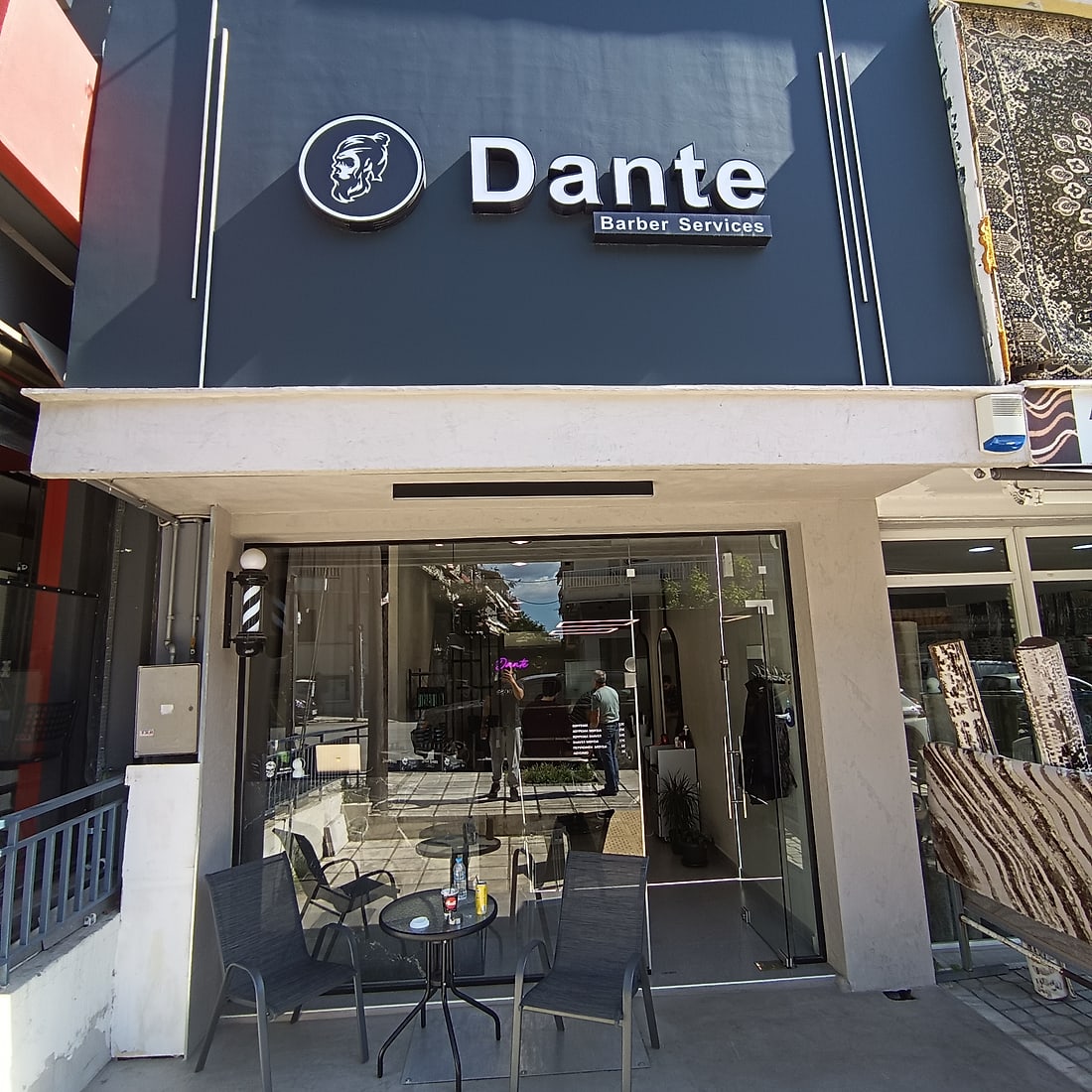 Η πρόσοψη του Dante Barber Services, με το στρογγυλό σήμα, τη τζαμαρία και το κουρείστικο φανάρι